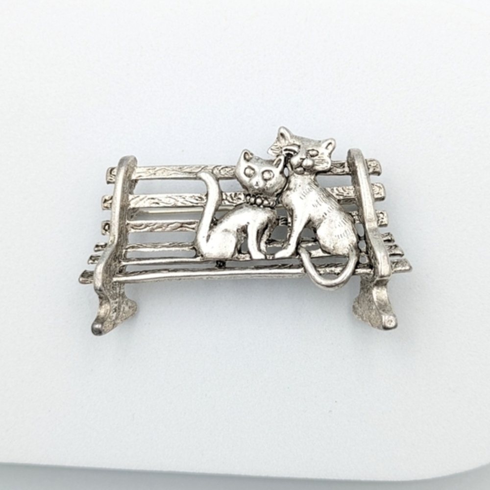 Vintage brooch of two cats on a park bench